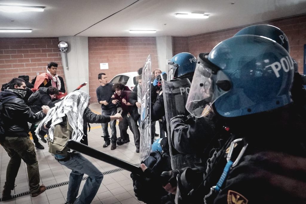 Italian riot police in Polizia helmets facing student protesters during the No Meloni Day clashes in Turin
